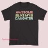 A retro-style T-shirt featuring the phrase "Awesome Like My Daughter" with bold, vintage-inspired lettering and vibrant colors.